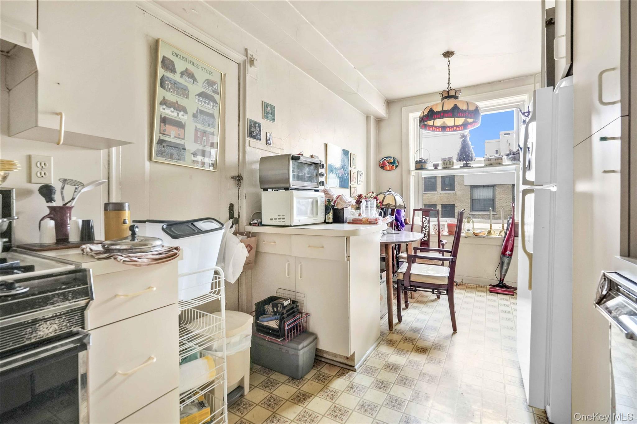 390 Riverside Drive, Unit 15D Manhattan, NY 10025 - Photo 6 of 18 Kitchen featuring white appliances, light floors, pendant lighting, light countertops, and extractor fan