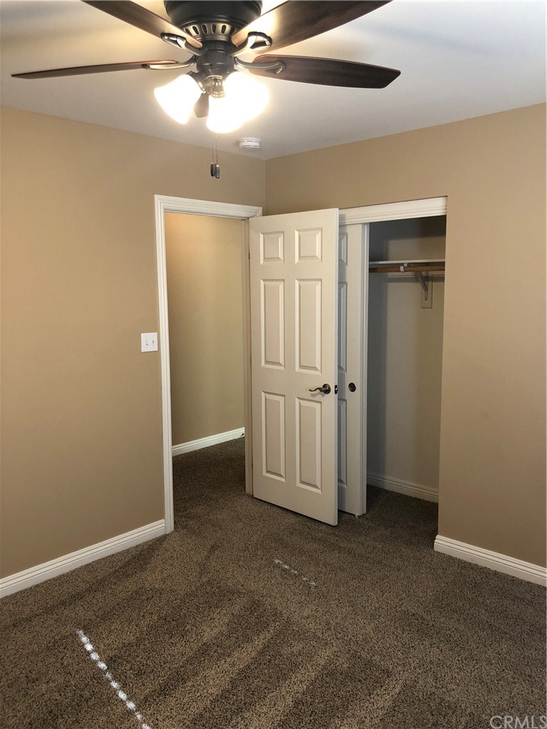 11612 Oasis Road Pinon Hills, CA 92372 - Photo 8 of 12 an empty room with closet and a ceiling fan