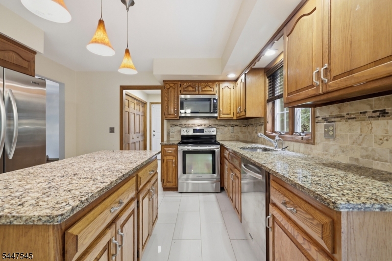 860 Glen Road Sparta, NJ 07871 - Photo 7 of 43 a kitchen with granite countertop a sink stove and refrigerator