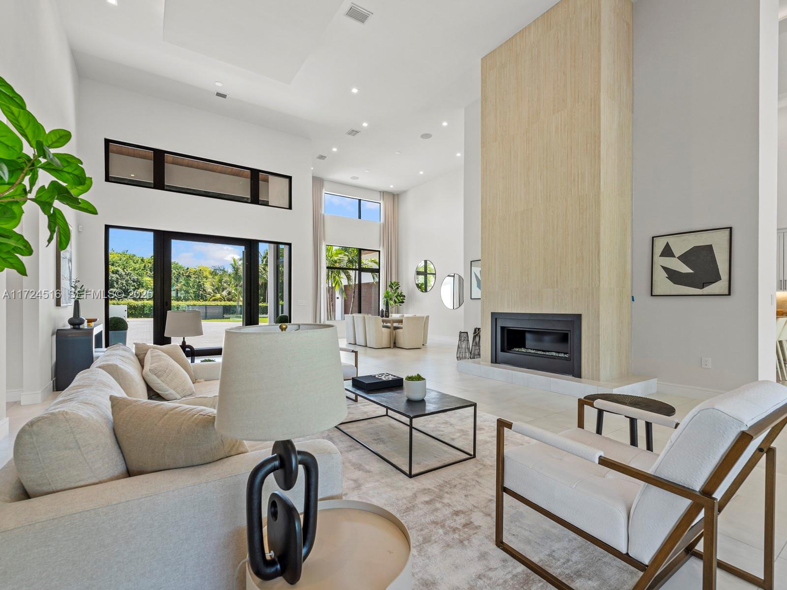 12025 Southwest 46th Street Miami, FL 33175 - Photo 2 of 45 a living room with furniture a fireplace and a floor to ceiling window