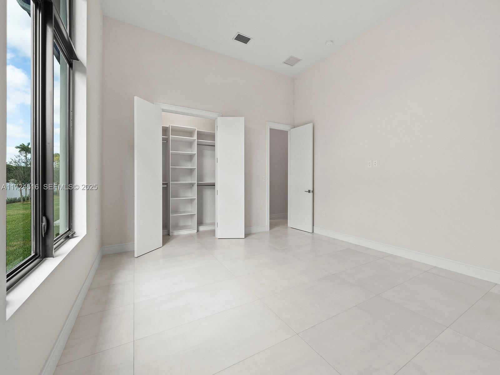 12025 Southwest 46th Street Miami, FL 33175 - Photo 23 of 45 an empty room with closet and a large window