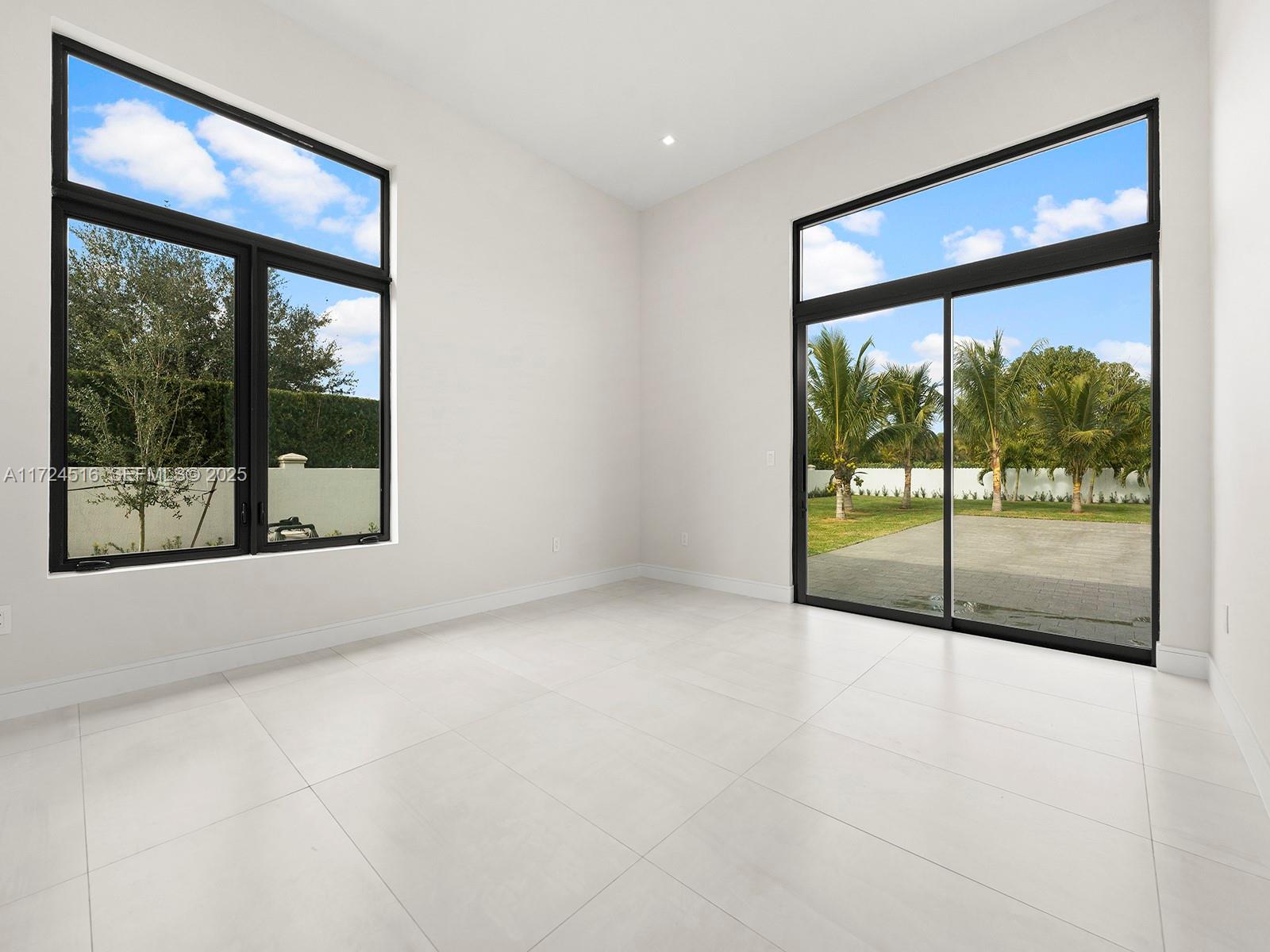 12025 Southwest 46th Street Miami, FL 33175 - Photo 32 of 45 an empty room with wooden floor and a large window with outer view