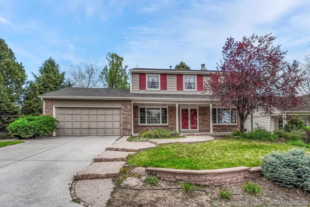 a front view of a house with a yard and potted plants