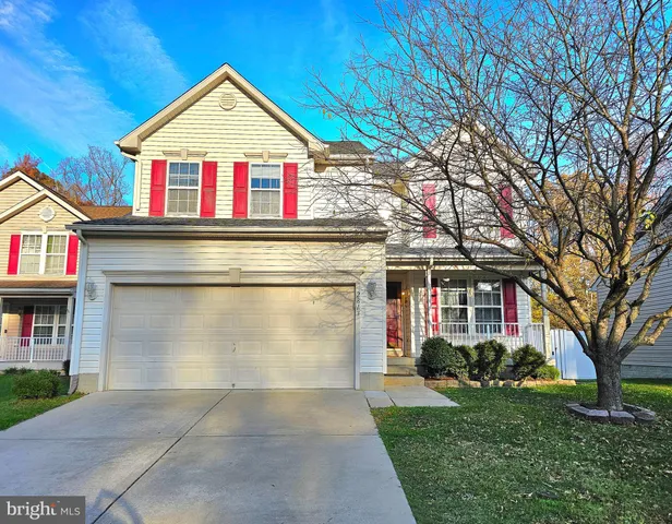 a view of a white house with large windows and a small yard