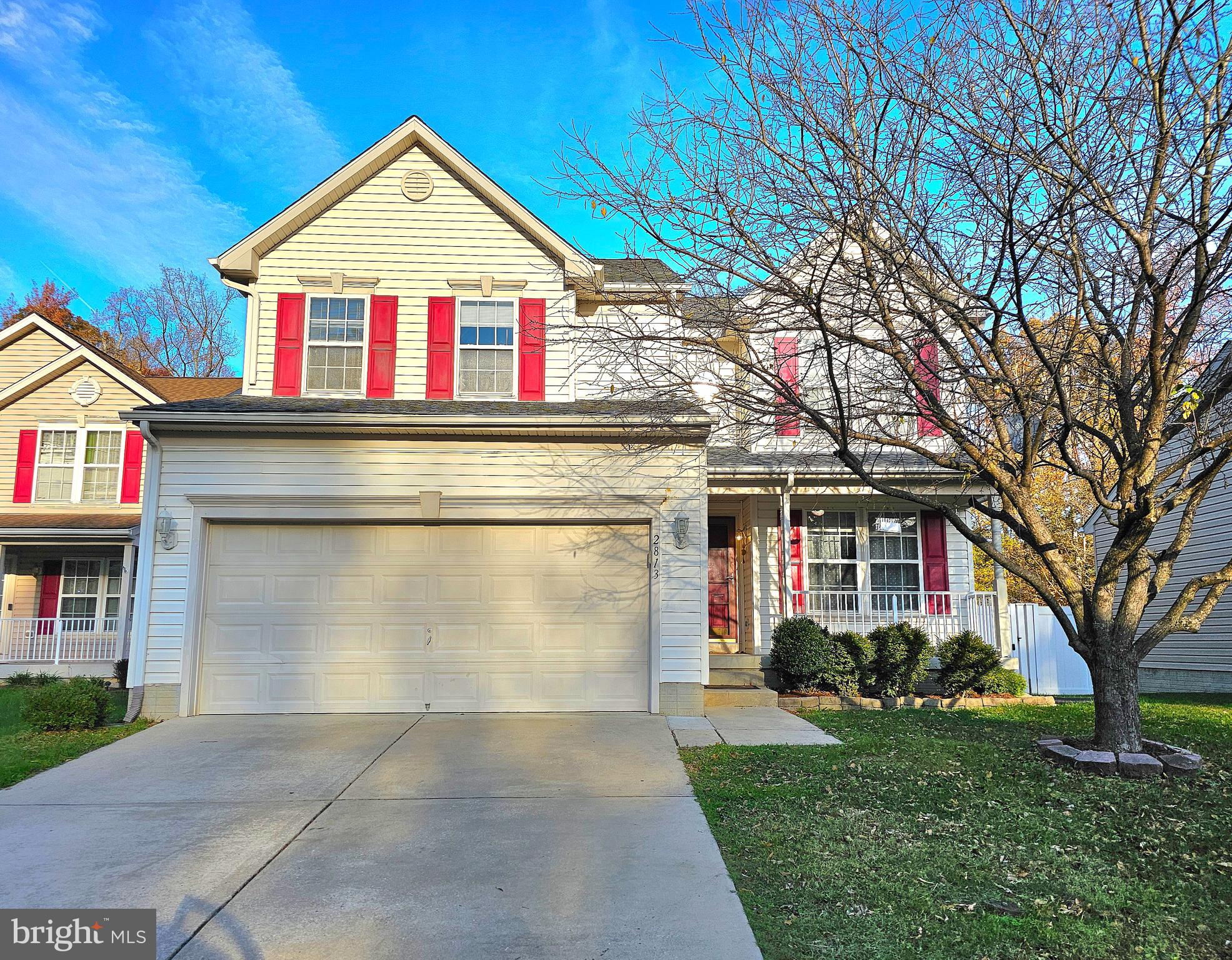 a view of a white house with large windows and a small yard