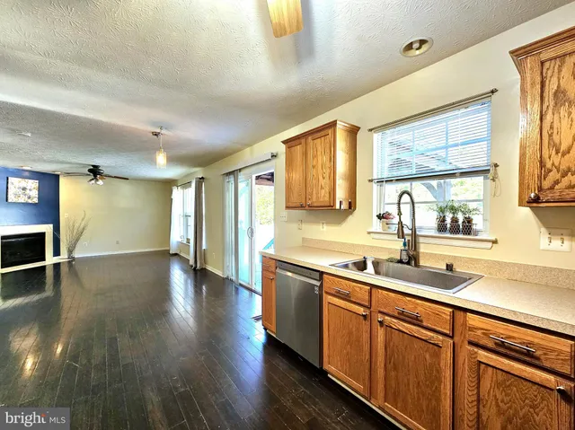 a bathroom with a granite countertop sink a toilet a mirror and bathtub