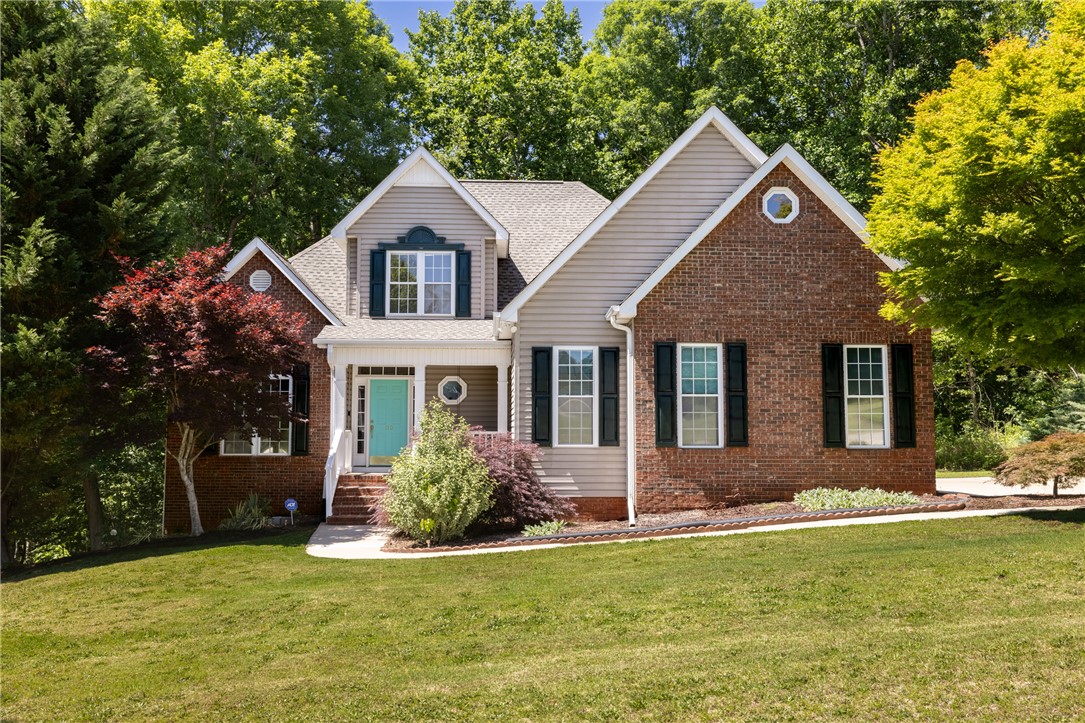 This charming home offers classic brick and siding construction with a vibrant front door.