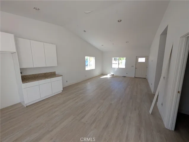 an empty room with wooden floor and a sink