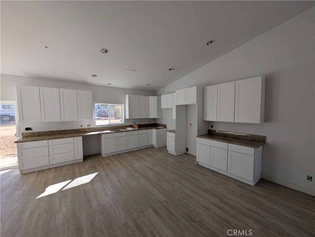 43145 Bob Cat Road Banning, CA 92220 - Photo 15 of 49 a kitchen with stainless steel appliances white cabinets and wooden floor