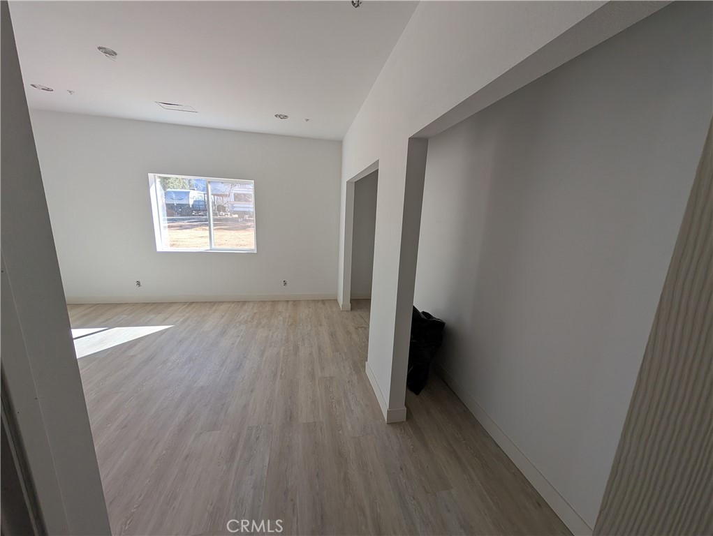43145 Bob Cat Road Banning, CA 92220 - Photo 25 of 49 an empty room with wooden floor and a window