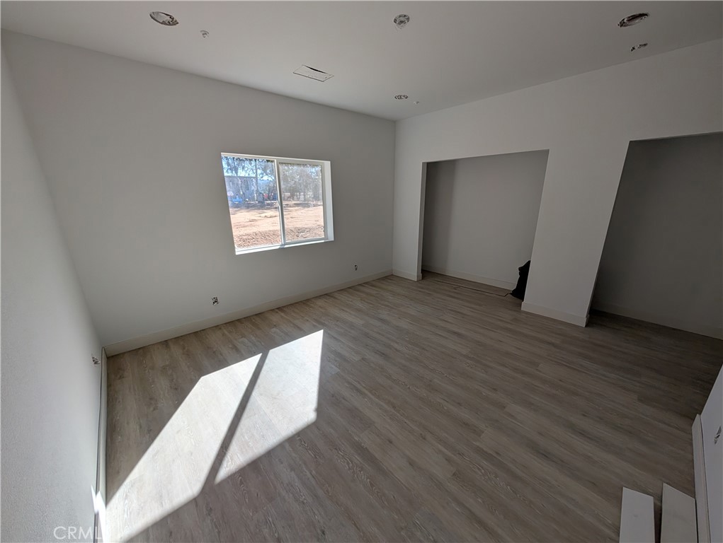 43145 Bob Cat Road Banning, CA 92220 - Photo 29 of 49 a view of an empty room with wooden floor and a window