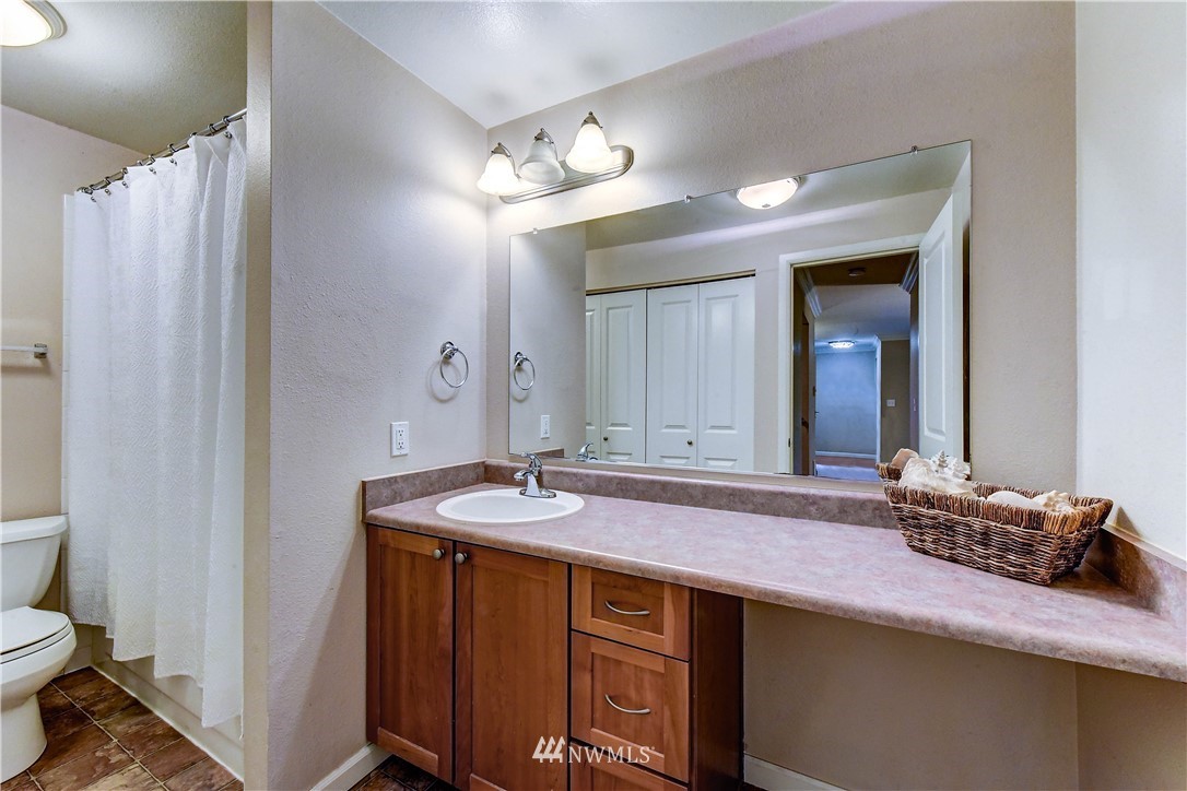 10831 Northeast 147th Lane, Unit R103 Bothell, WA 98011 - Photo 12 of 15 a bathroom with a granite countertop sink and a mirror