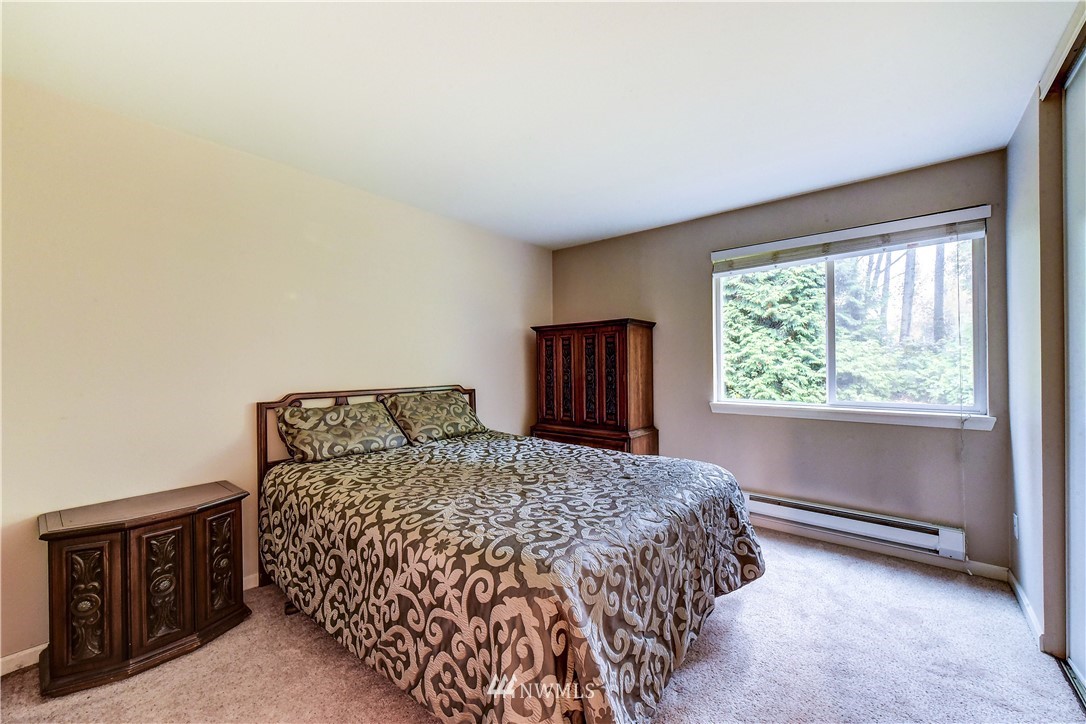 10831 Northeast 147th Lane, Unit R103 Bothell, WA 98011 - Photo 13 of 15 a bedroom with a bed and a window