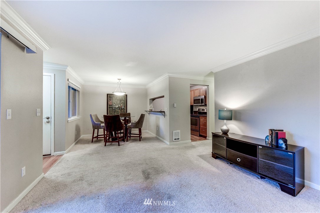 10831 Northeast 147th Lane, Unit R103 Bothell, WA 98011 - Photo 6 of 15 a living room with furniture and a dining table with projector