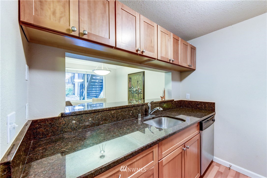 10831 Northeast 147th Lane, Unit R103 Bothell, WA 98011 - Photo 10 of 15 a kitchen with granite countertop a sink a stove and cabinets