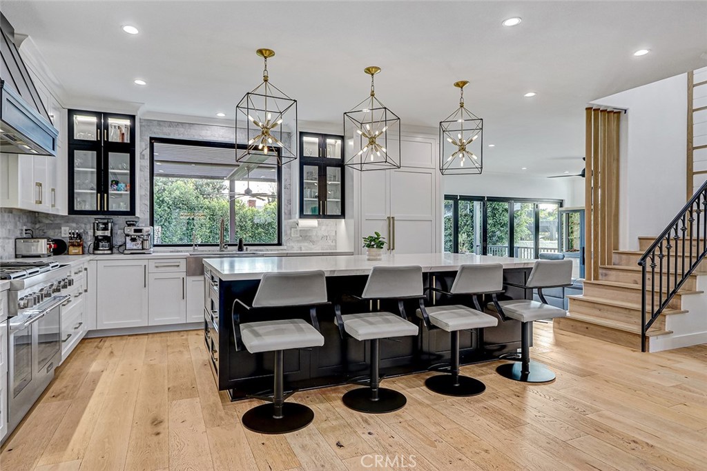1852 6th Street Manhattan Beach, CA 90266 - Photo 29 of 60 a kitchen with stainless steel appliances granite countertop wooden floor dining table and chairs