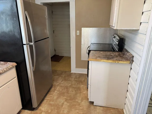 a kitchen with a refrigerator and microwave