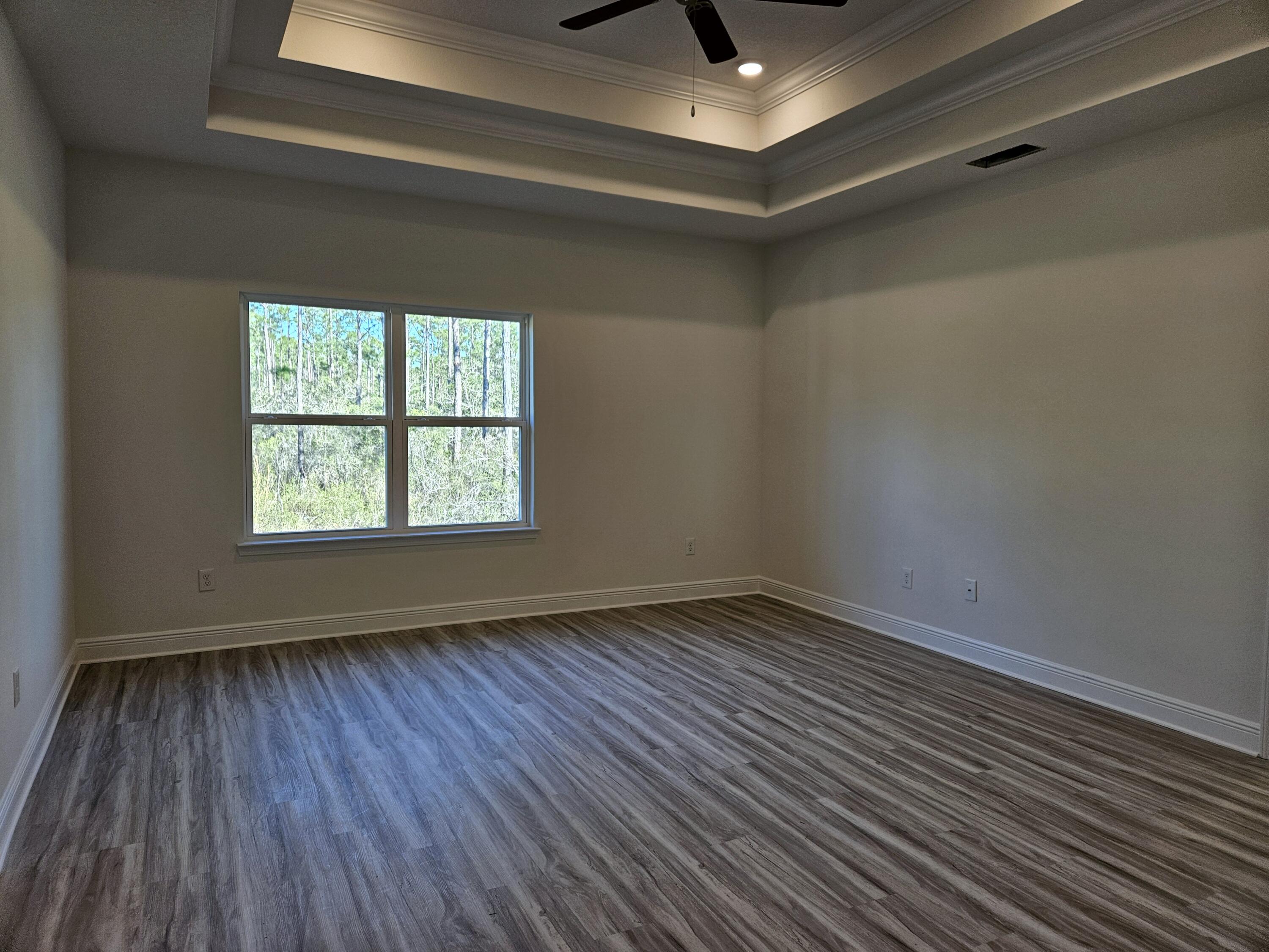 7 Nest Lane Santa Rosa Beach, FL 32459 - Photo 7 of 16 an empty room with wooden floor chandelier fan and windows