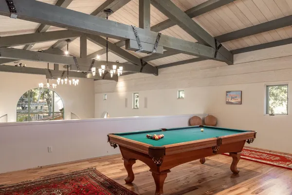 a room with pool table and windows