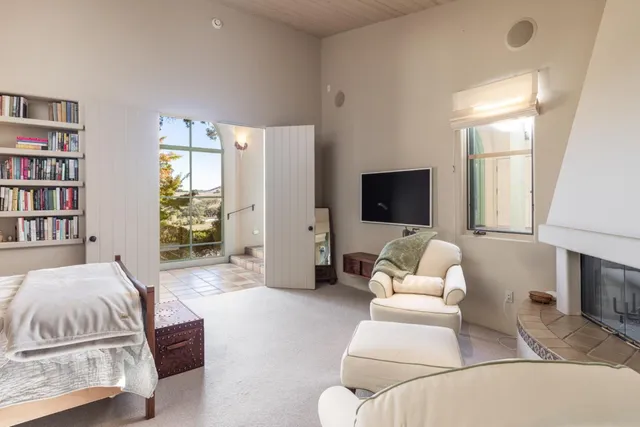 a living room with a couch bookshelf and a flat screen tv