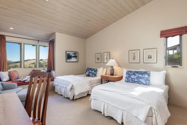 a bedroom with two beds and a large window