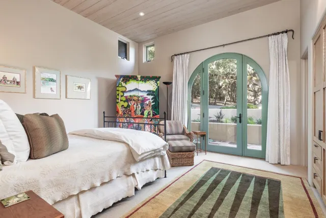 a spacious bedroom with a bed and a large window