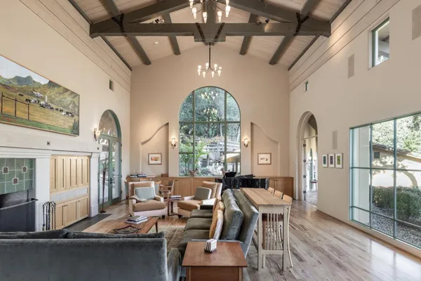 a living room with furniture chandelier and a large window
