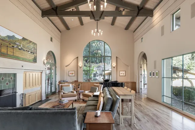 a living room with furniture chandelier and a large window