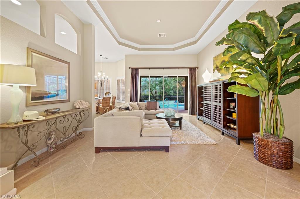 a living room with furniture a floor to ceiling window and potted plant