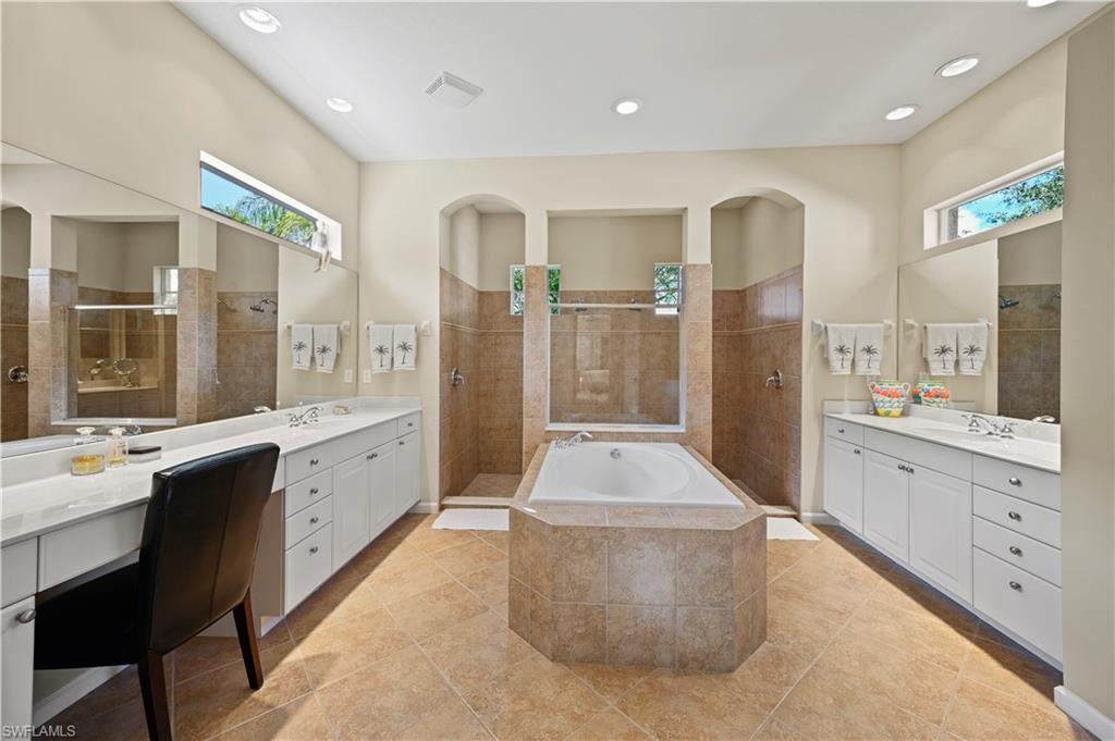 7950 Founders Circle Naples, FL 34104 - Photo 16 of 43 a large bathroom with a double vanity sink a large mirror and a shower