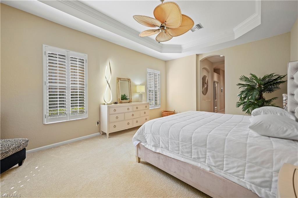 7950 Founders Circle Naples, FL 34104 - Photo 28 of 43 a bedroom with a large bed and a chandelier