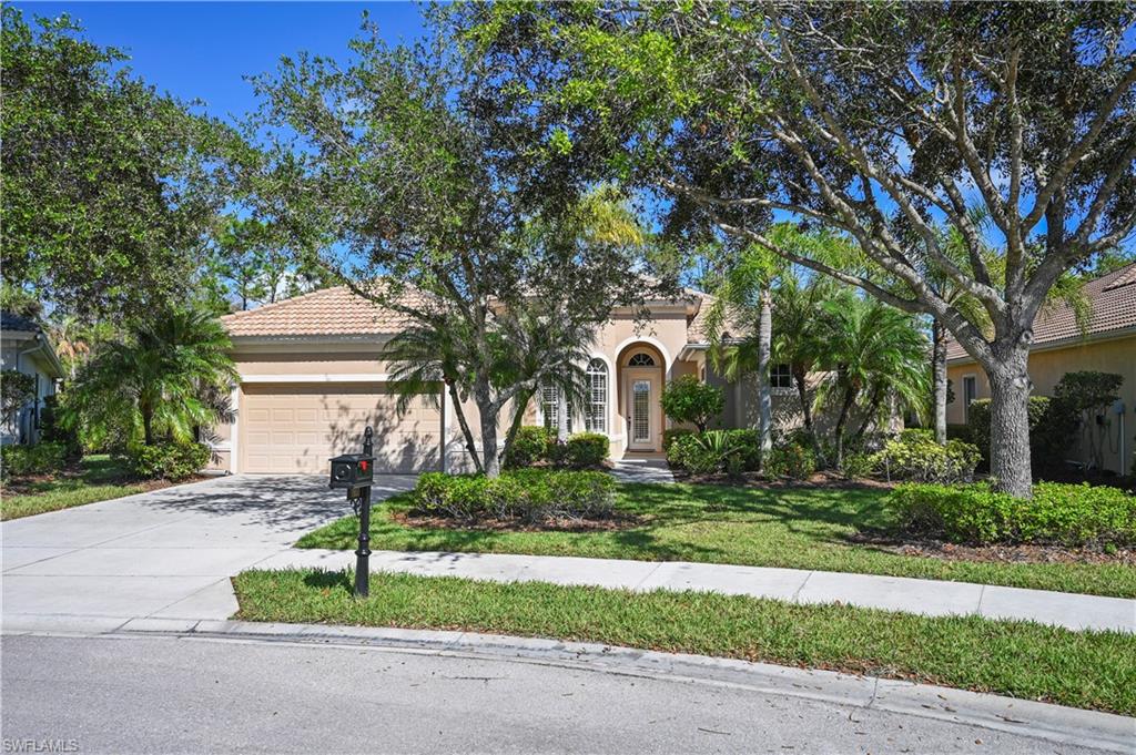 7950 Founders Circle Naples, FL 34104 - Photo 3 of 43 a front view of a house with a yard and potted plants