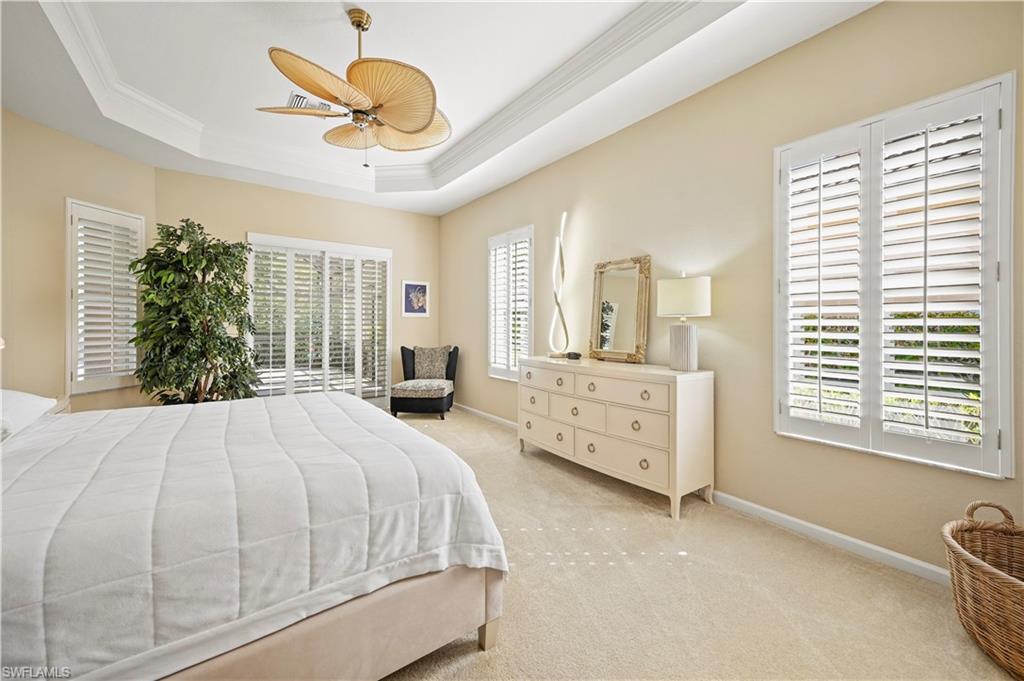 7950 Founders Circle Naples, FL 34104 - Photo 31 of 43 a spacious bedroom with a large bed and a chandelier