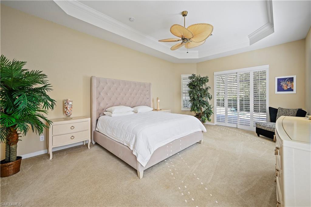 7950 Founders Circle Naples, FL 34104 - Photo 32 of 43 a spacious bedroom with a bed and a chandelier