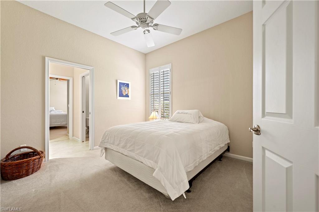 7950 Founders Circle Naples, FL 34104 - Photo 34 of 43 a bedroom with a bed and a chandelier