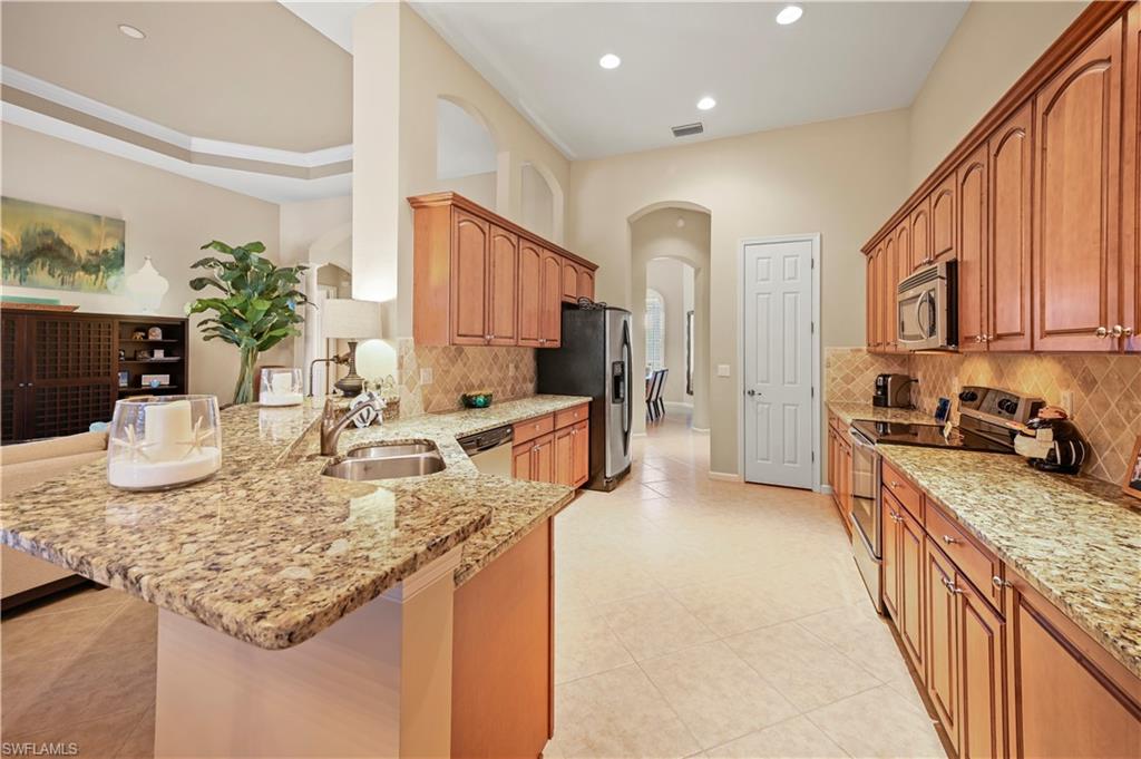 7950 Founders Circle Naples, FL 34104 - Photo 7 of 43 a kitchen with sink refrigerator and stove
