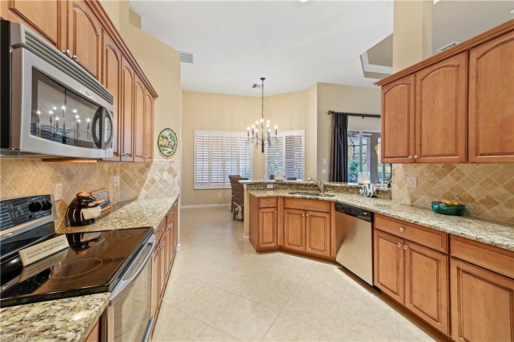 7950 Founders Circle Naples, FL 34104 - Photo 8 of 43 a kitchen with stainless steel appliances granite countertop a stove a sink and a microwave