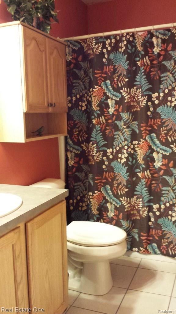 7690 South Eston Road Clarkston, MI 48348 - Photo 15 of 26 Main full bath with ceramic tile floor and extra cabinet space