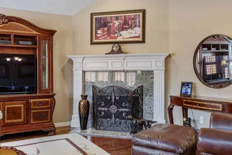 a living room with furniture a mirror and a fireplace