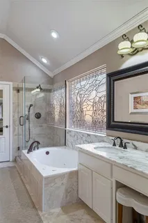a bathroom with a granite countertop tub a sink and a large mirror