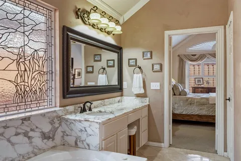 a en suite bathroom with a granite countertop sink and a mirror