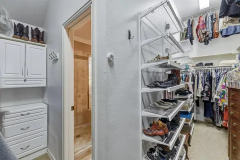 a view of walk in closet with clothes and shoes
