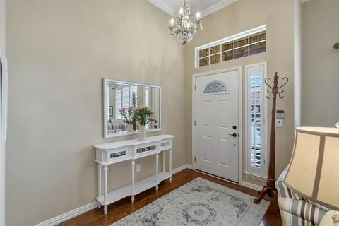 a view of a hallway with windows and chandelier