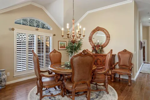 a dining room with furniture a chandelier and wooden floor