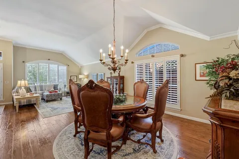 a dining room with furniture a chandelier and wooden floor