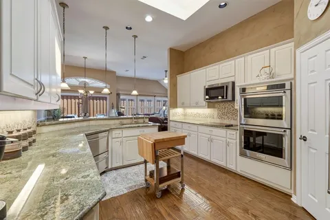 a kitchen with kitchen island granite countertop a stove a sink and a refrigerator