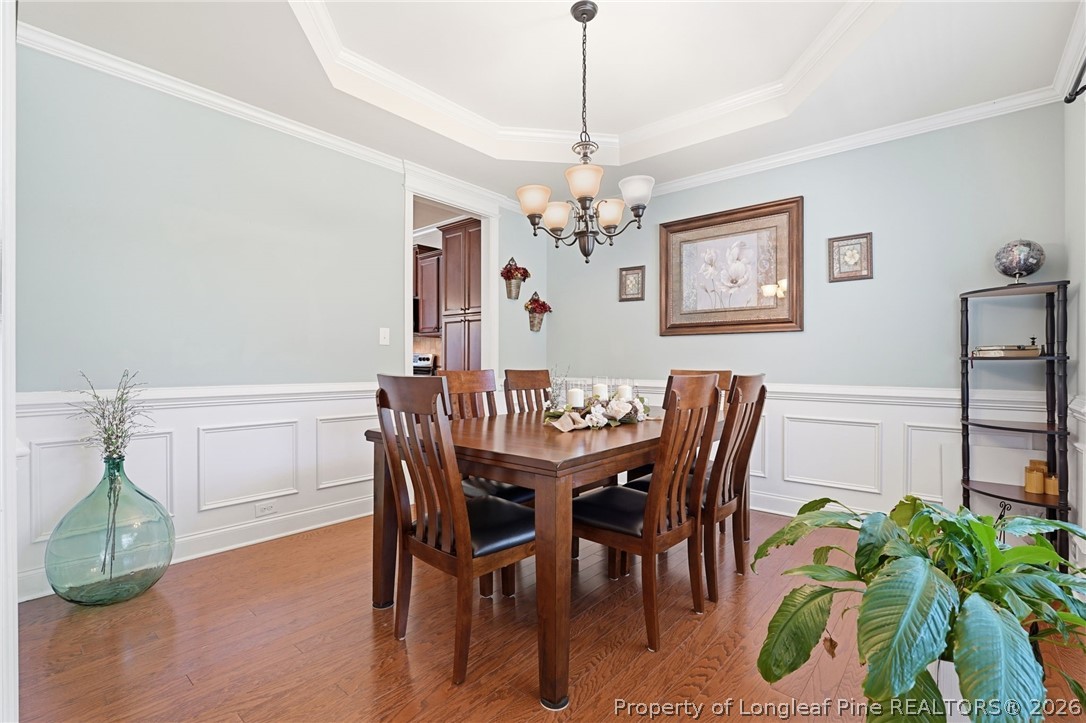 886 Micahs Way North Spring Lake, NC 28390 - Photo 4 of 50 a dining room with furniture potted plants and wooden floor
