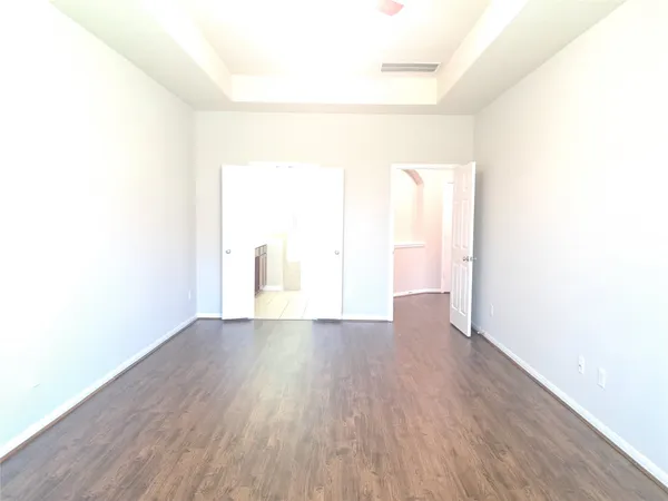 a view of a room with wooden floor and a window