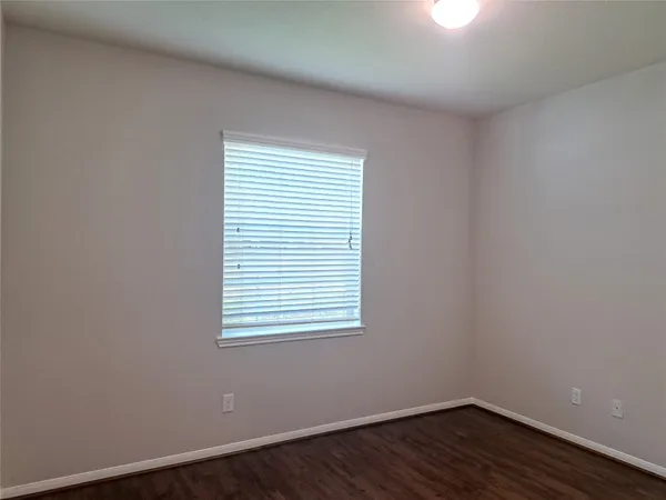 an empty room with wooden floor & closet area