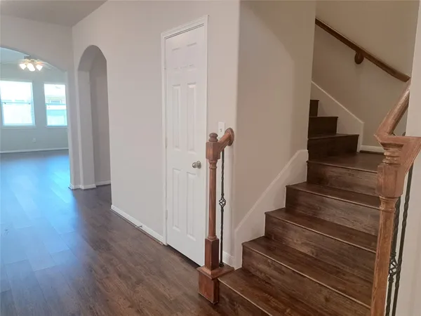 a view of a hallway with wooden floor and stairs
